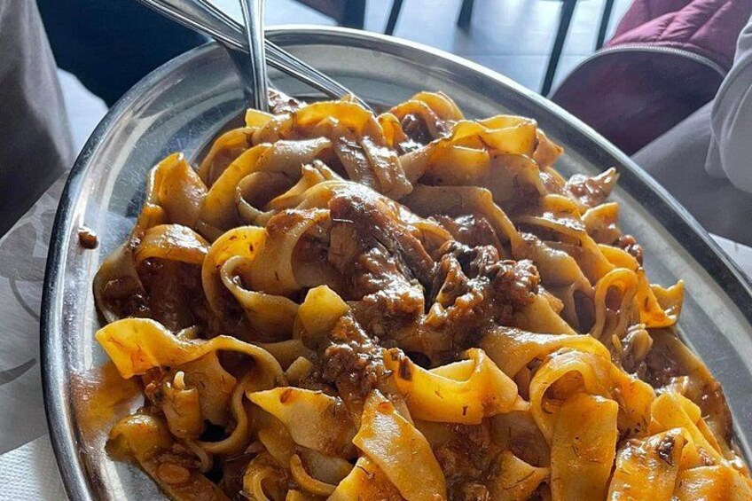 Une assiette de pâtes avec une sauce à la viande. 3