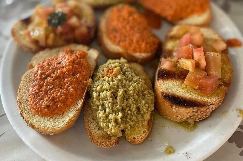 Une assiette contenant différentes sortes de bruschettas, chacune garnie d'une préparation différente. 4