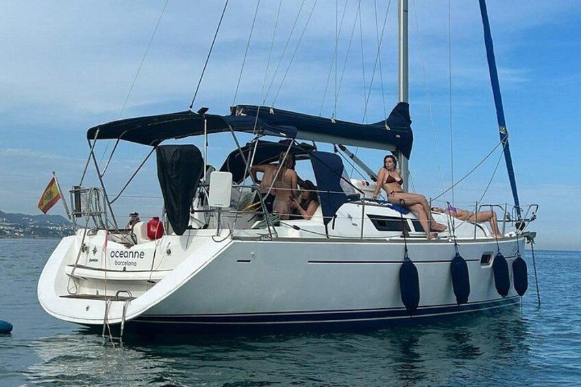A sailboat named 'oceanne' with a flag, anchored in calm waters. 2