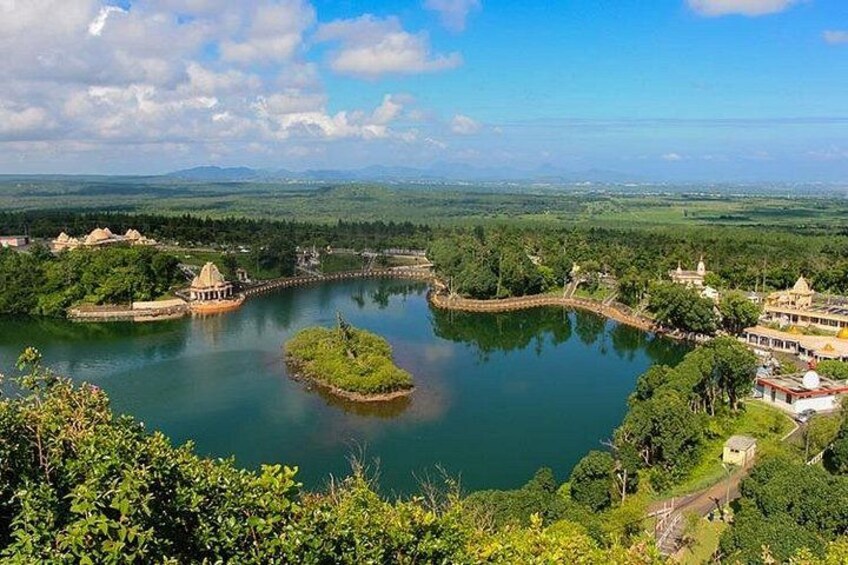 A lake surrounded by lush greenery and traditional buildings. 1