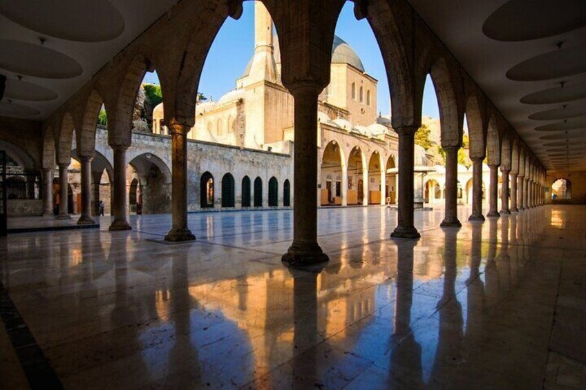 Un patio interior con arcos y un edificio al fondo. 5