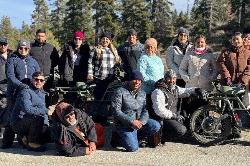 Un grupo de personas posando con vehículos todo terreno en un bosque. 5