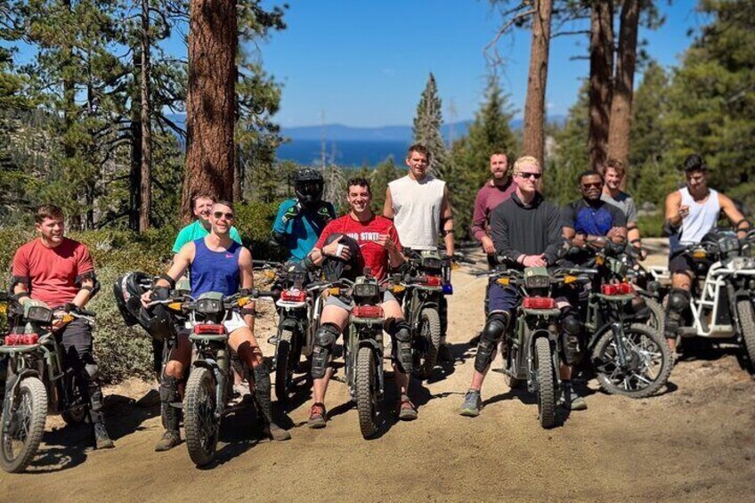 A group of people on ATVs on a dirt trail surrounded by trees. 5