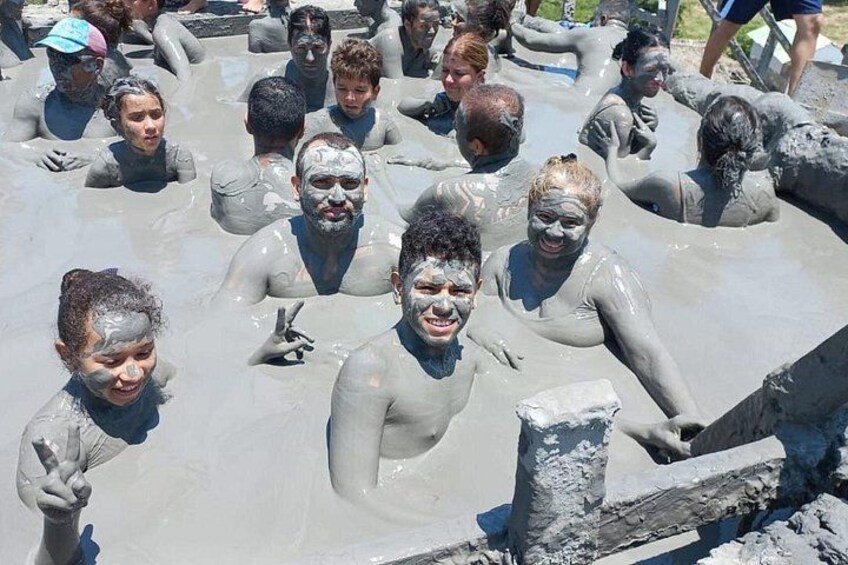 Un grupo de personas en un cuerpo de agua fangosa, posiblemente un baño de barro o una fuente de agua natural. 4