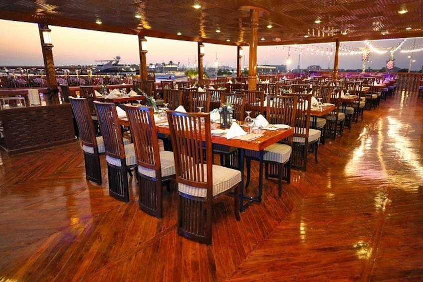 An indoor restaurant with wooden flooring and tables set for dining. 3