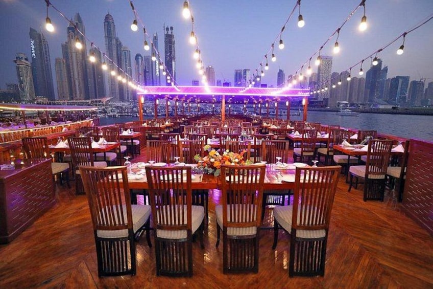 A waterfront restaurant with tables and chairs, city skyline in the background. 5