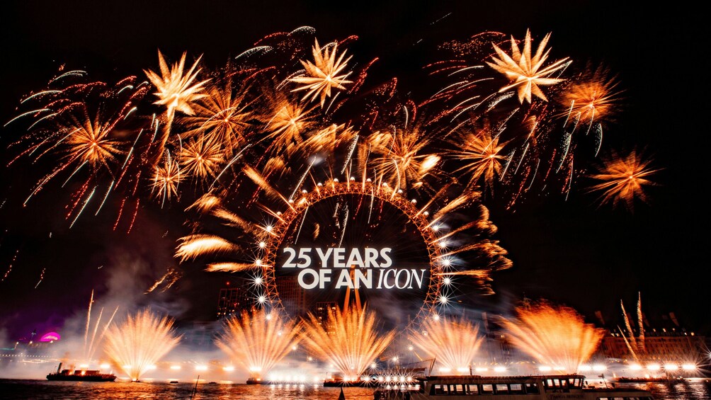 A fireworks display over a body of water with a Ferris wheel in the background. 2