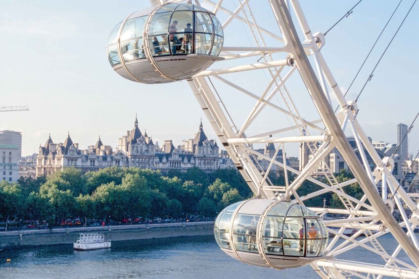 A Ferris wheel with passenger capsules and a river with a boat in the foreground. 4