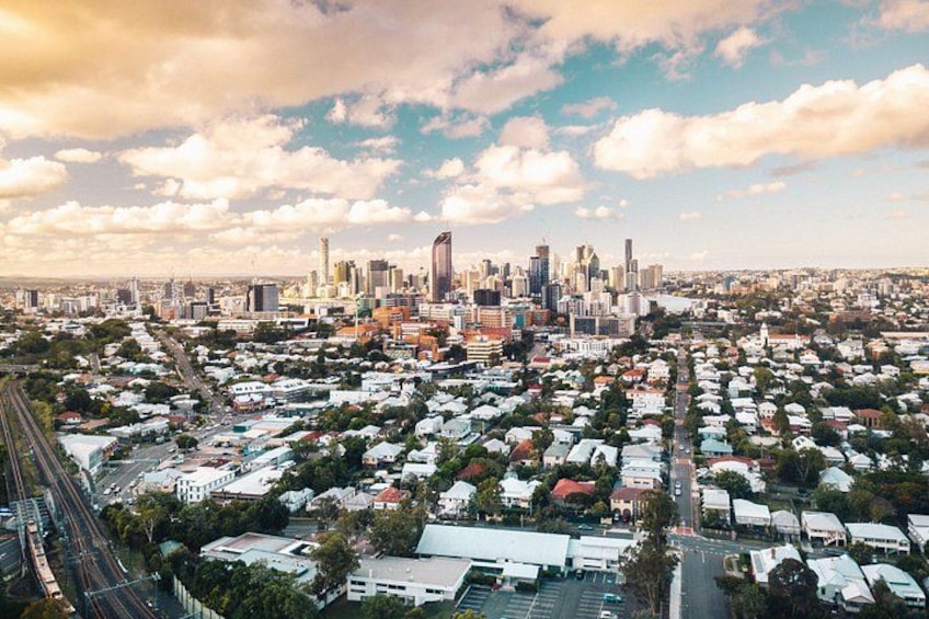 A cityscape with a dense residential area, a prominent skyscraper, and a clear sky. 4