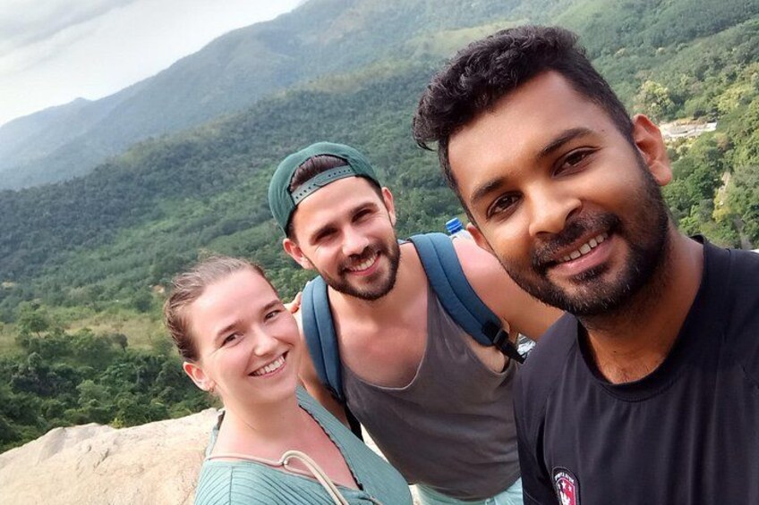 Drie personen op een berg, met begroeiing op de achtergrond. 1