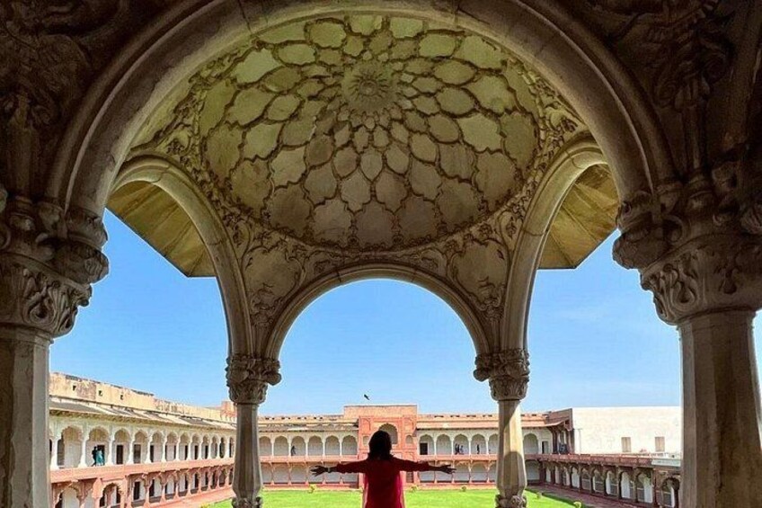 An architectural structure with arches and columns, a courtyard, and a distant building. 4