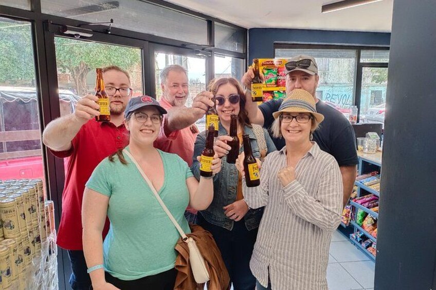 A group of people holding beer bottles inside a store. 5