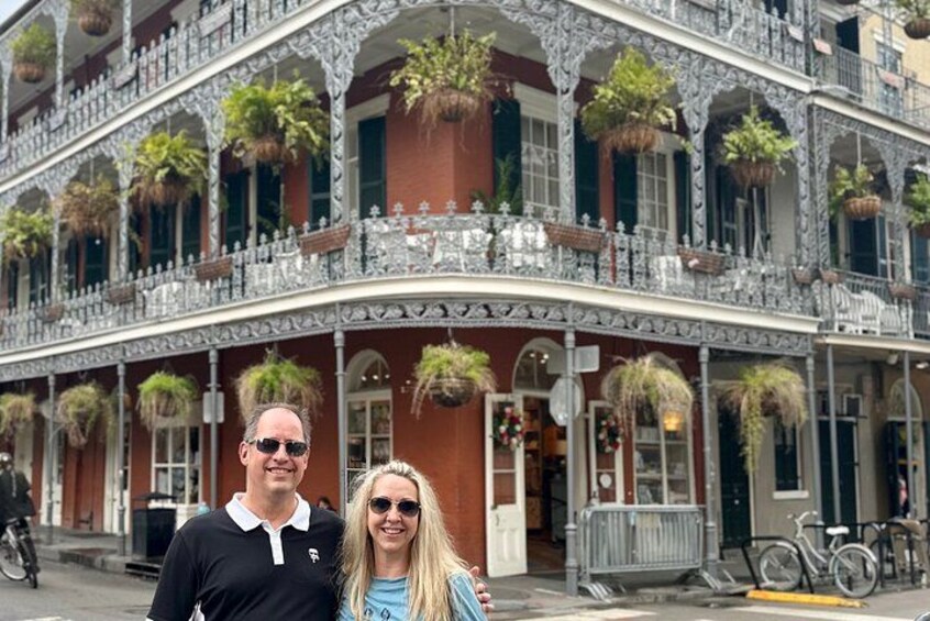 Un edificio histórico con balcones ornamentales y plantas colgantes. 1
