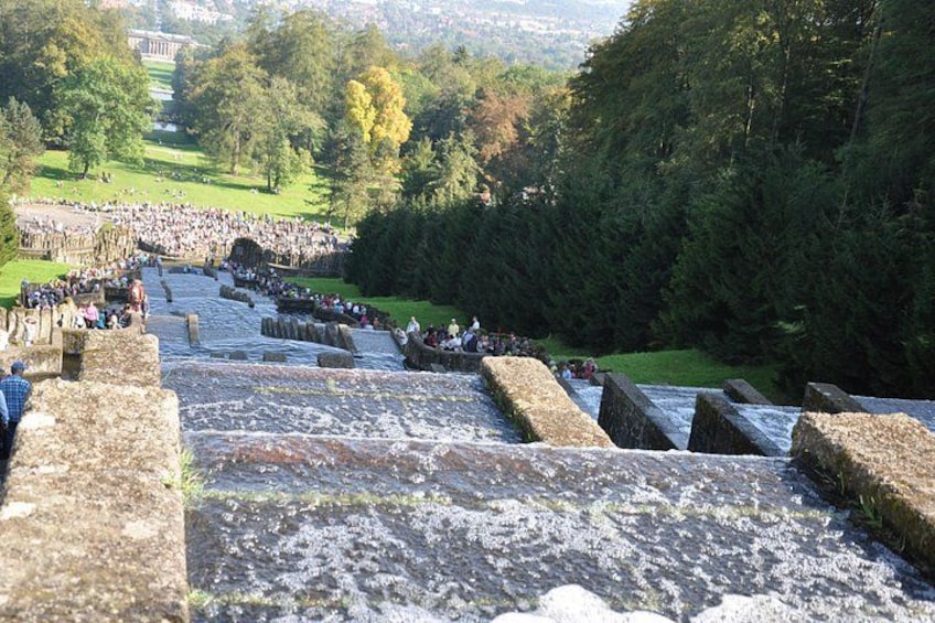 A stone staircase leading up a hill with people gathered at the top. 3