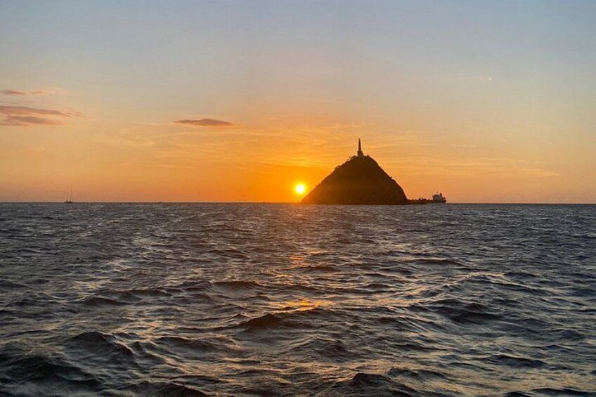A sunset over the ocean with a small island silhouette. 5