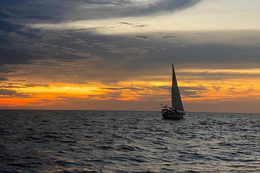 A sailboat on the ocean during sunset. 3