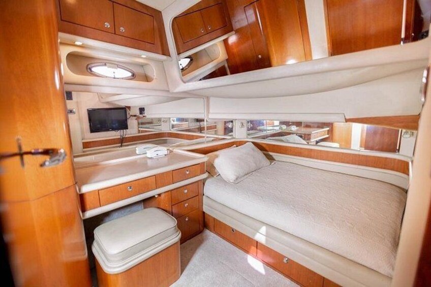 A compact, well-organized interior of a motorhome with a bed, kitchenette, and storage cabinets. 5