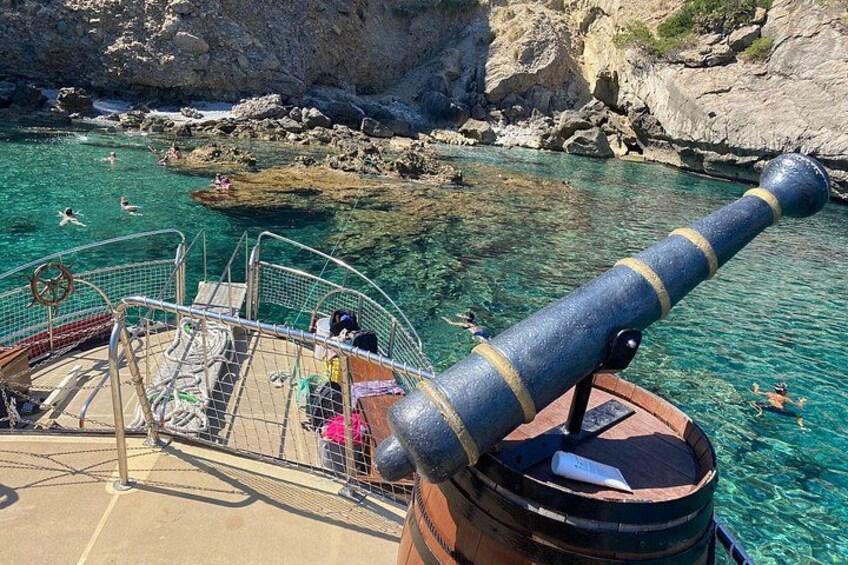 Une mer d’un bleu profond, des falaises rocheuses et un canon sur un bateau. 3