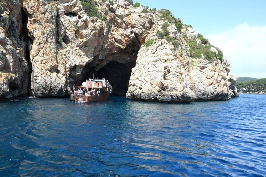 Un bateau près d’une côte rocheuse, avec une formation géologique ressemblant à une grotte. 4