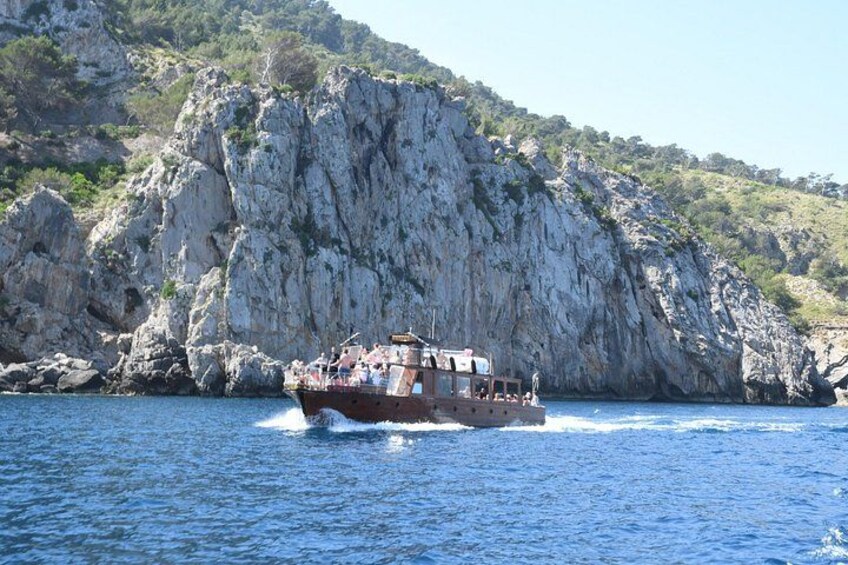 Un bateau sur une étendue d’eau, avec des falaises rocheuses en arrière-plan. 5