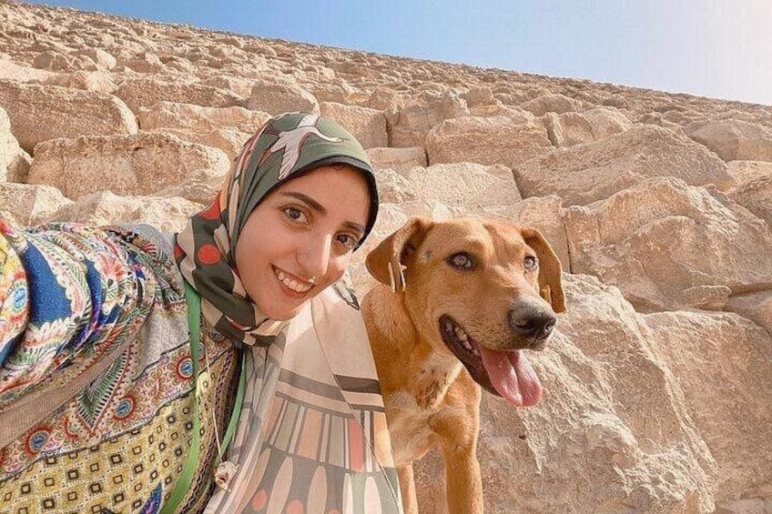 A person with a dog in front of a rocky landscape. 1