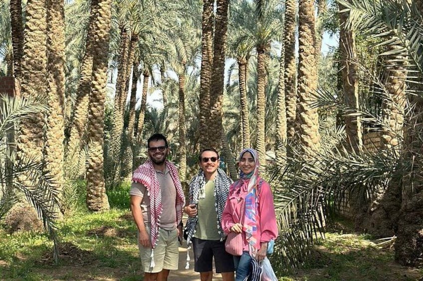Three people standing in a palm grove. 3