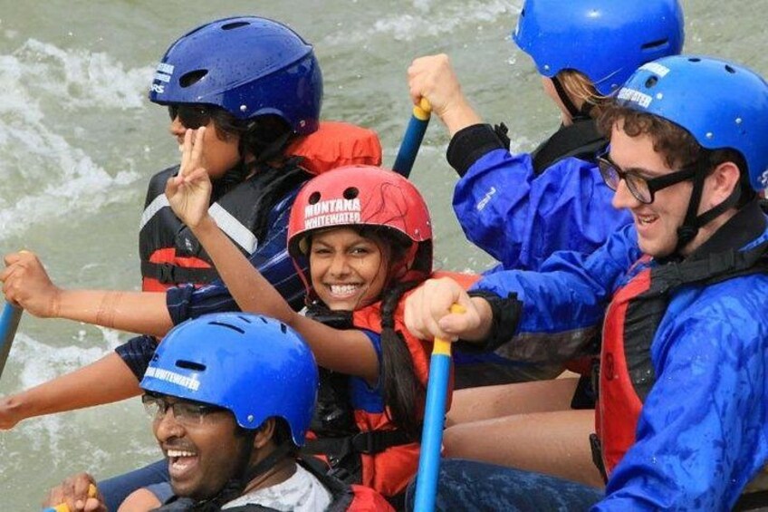 People in a raft wearing helmets and life jackets. 3