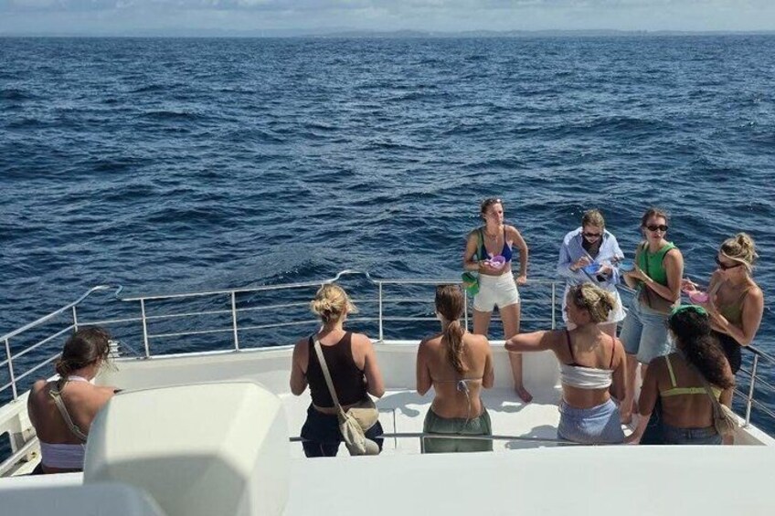 Un groupe de personnes se trouve sur un bateau, avec l’océan en arrière-plan. 3