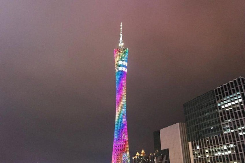 Ein hoher, beleuchteter Turm mit spiralförmigem Design, umgeben von modernen Gebäuden. 5