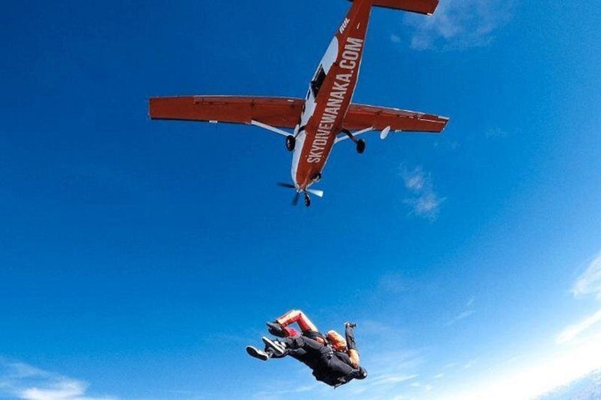 A red and white aircraft flying in the sky. 5