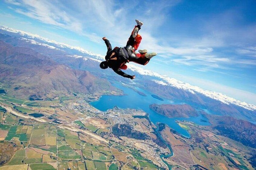 Iemand parachutes boven een bergachtig landschap met een meer. 2