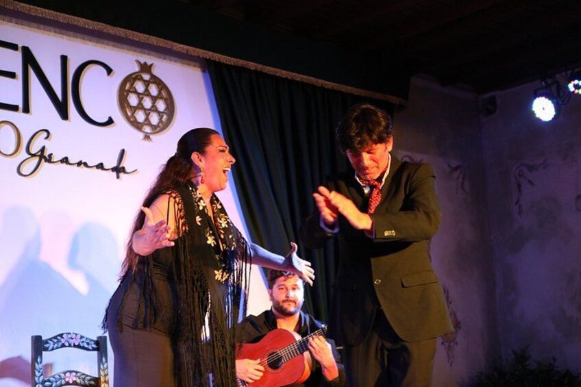 A stage with a microphone stand, a guitar, and a person playing the guitar. 5