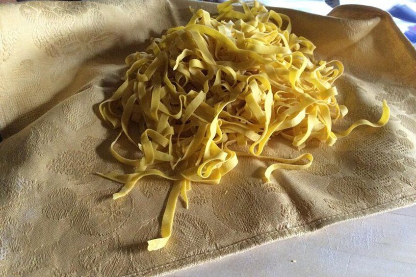 Ein Haufen gelber Pasta auf einem strukturierten beige farbenen Tuch. 3