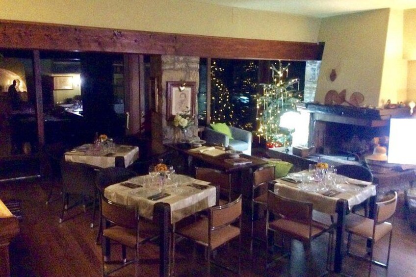 Ein gemütliches Restaurant mit Holzbalken, gedeckten Tischen und einem Kamin. 4