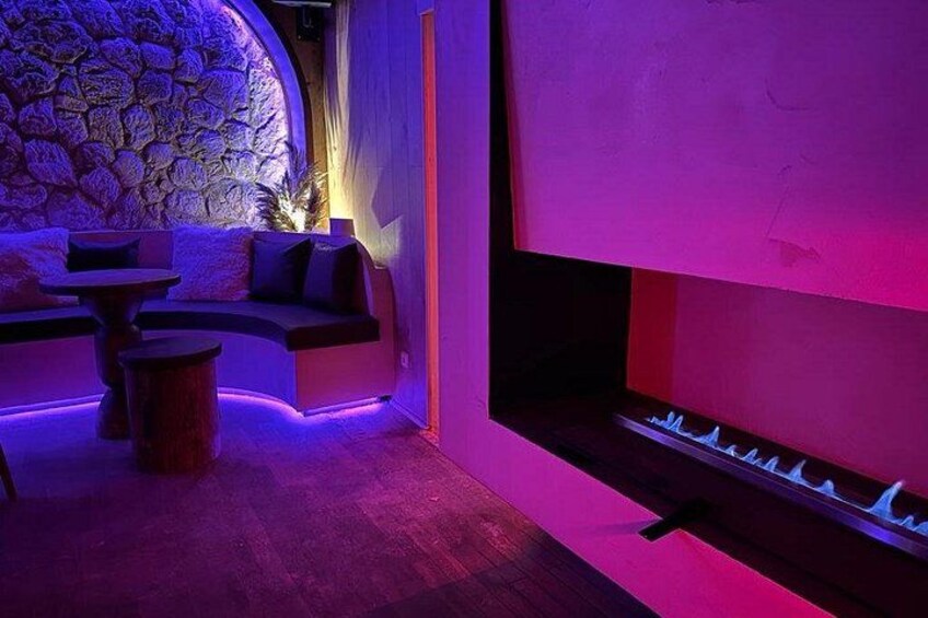 Un salón moderno con pared de piedra, un sofá y una chimenea. 3