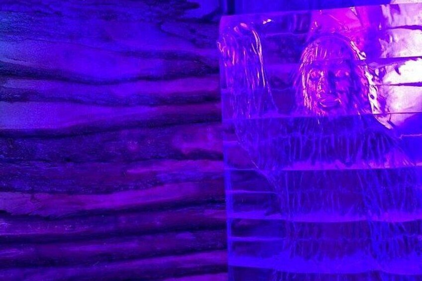 Una escultura iluminada de color morado con una superficie reflectante. 5