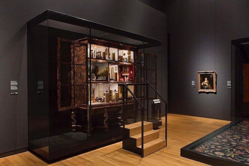 Une galerie d’art dotée d’une vitrine, d’un escalier en bois et d’un tableau encadré accroché au mur. 4