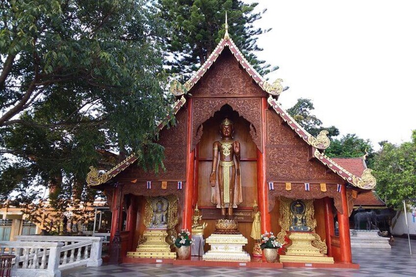 Un temple abritant une grande statue de Bouddha, doté d’une architecture complexe et surmonté d’un toit rouge. 3