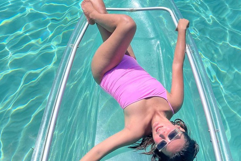 Una persona sdraiata su uno scivolo d'acqua trasparente in una piscina. 4