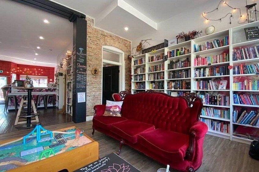 A cozy room with a red sofa, a bookshelf filled with books, and a chalkboard with writing. 3