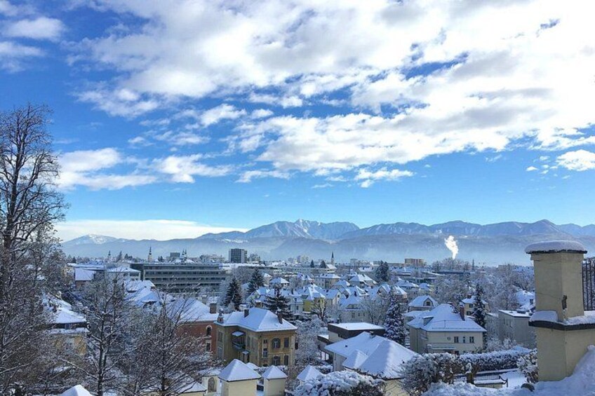 A snowy town with buildings, mountains, and a clear sky. 3