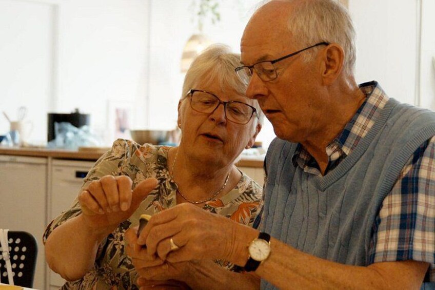 An elderly couple sitting at a kitchen table, engaged in a conversation. 5