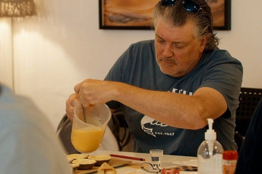 A person pouring a yellow liquid into a glass. 3