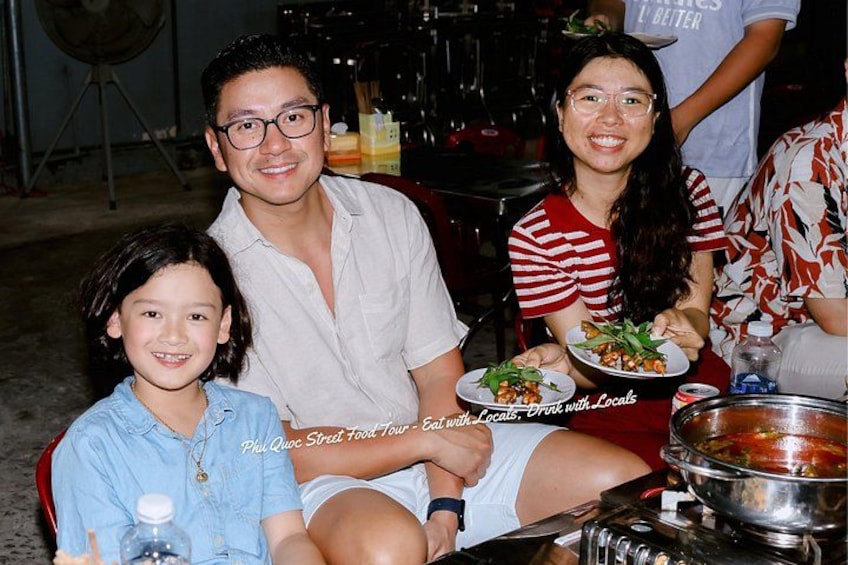 A group of people seated at a table with food and drinks. 4