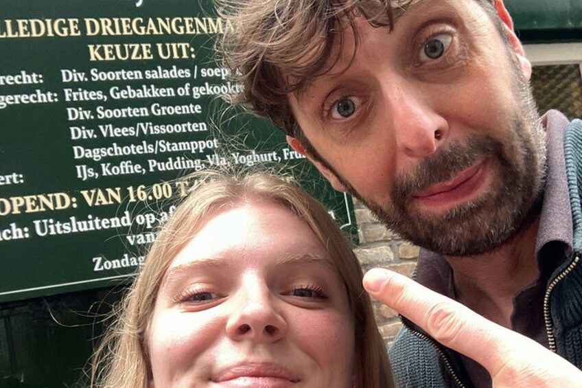 Eine Person macht ein Selfie mit einem Schild im Hintergrund. 2