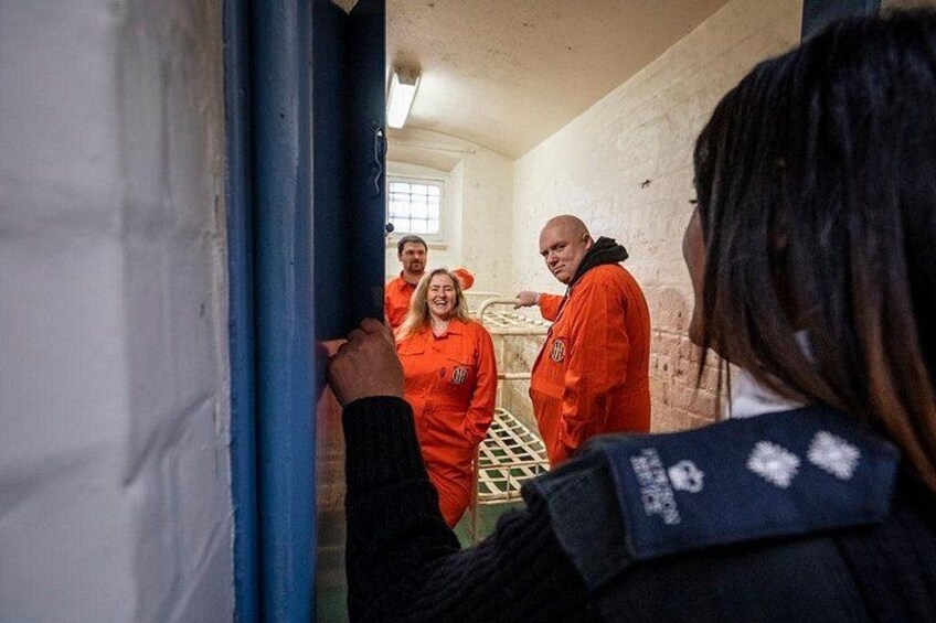 Une personne portant une veste bleue, une personne portant un uniforme orange et une personne portant un uniforme orange avec un écusson blanc. 5