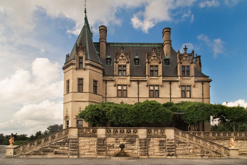 A historic building with a steeply pitched roof, ornate gables, and a prominent tower. 5
