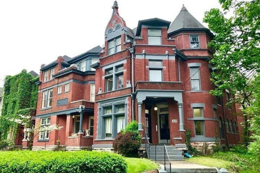 A Victorian-style brick house with a turret and a well-maintained garden. 2