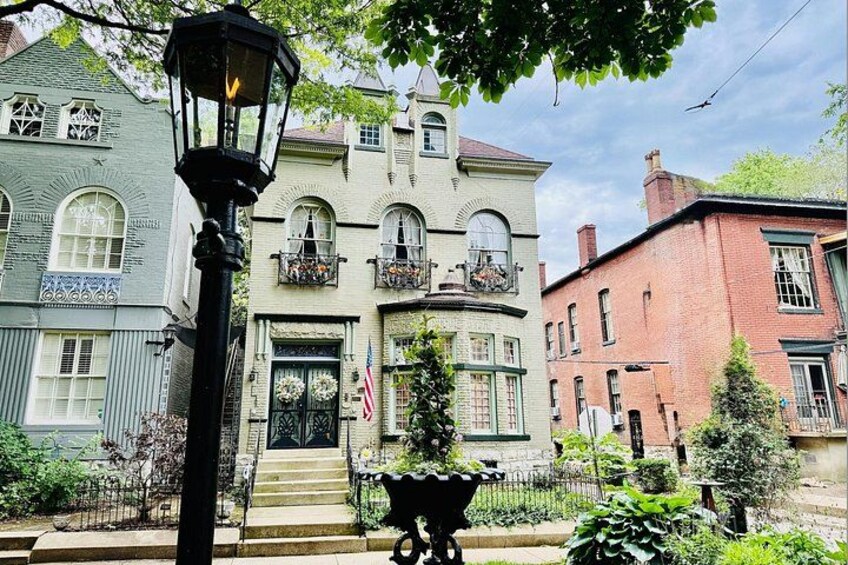 Une rue bordée de bâtiments historiques, un lampadaire et un petit jardin. 3