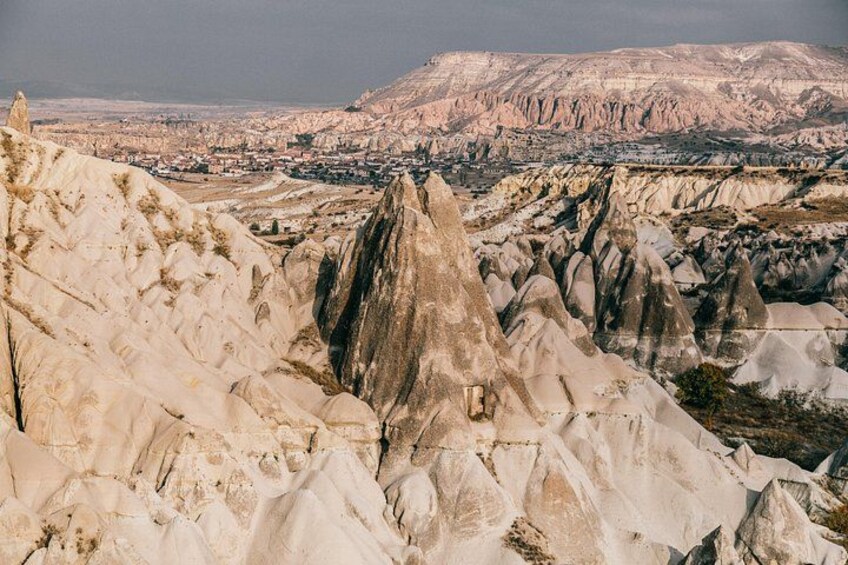 A rugged landscape with prominent rock formations and a distant cityscape. 3